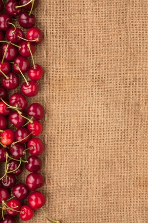 Cherry lying on sackcloth, place for textの写真素材