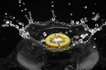 Kiwi falling into the water on a black backgroundの写真素材