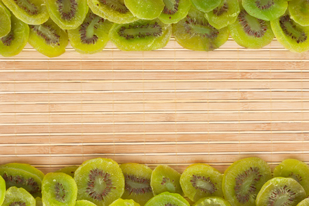 Dried kiwi lying on a bamboo mat, as backgroundの写真素材