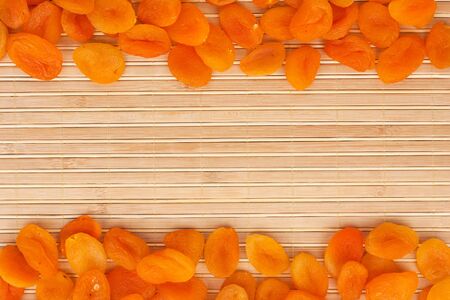 Dried apricots lying on a bamboo mat as backgroundの写真素材