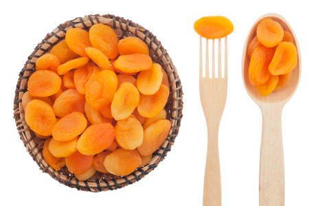 Spoon, a fork, a plate with dried apricots, isolated on white backgroundの写真素材