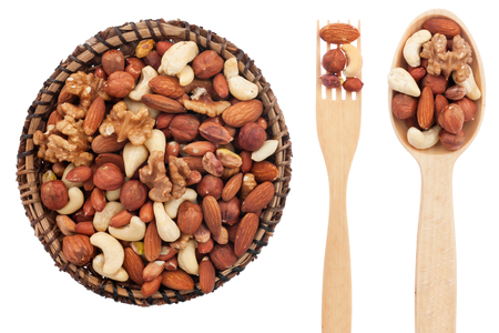 Spoon, a fork, a plate with  nuts, isolated on white backgroundの写真素材