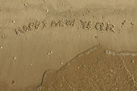 Inscription Happy new year on the sand, can be used as background