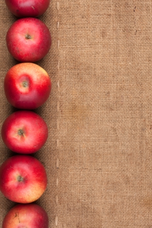 Red apples lie on sackcloth, to the menuの写真素材