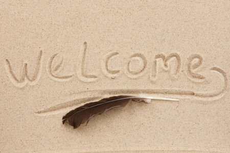 Inscription welcome written on the sand featherの写真素材