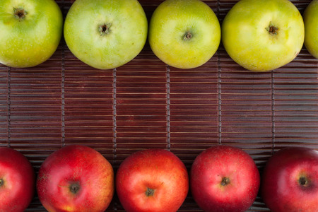 Green and red apples lie on the bamboo mat , with place for your text