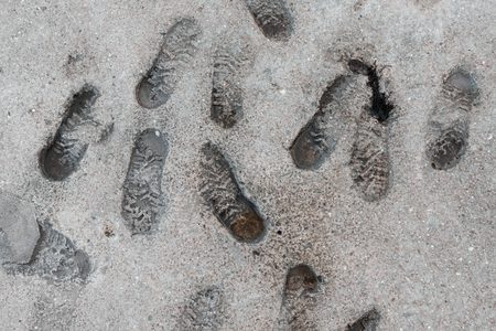Human footprints in the concrete on the waterfront, can be used as backgroundの写真素材