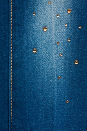 Yellow seam and yellow rhinestones on denim, background, textureの写真素材