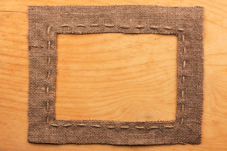Frame of burlap, lies on a background of wood, with place for your textの写真素材