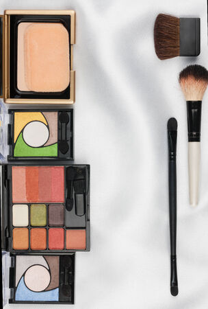 Beautiful picture of cosmetic  on white satin, with space for your textの写真素材