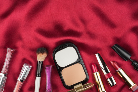 Beautiful picture of cosmetic  on red satin, with space for your textの写真素材