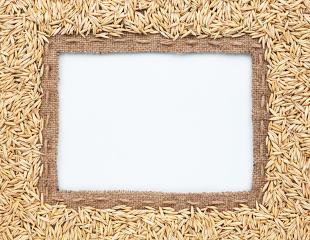Frame of burlap and  oats  beans, lying on a white backgroundの写真素材