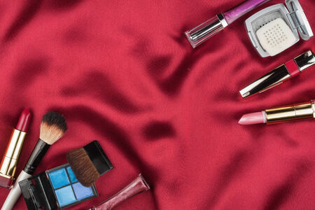 Beautiful picture of cosmetic  on red satin, with space for your textの写真素材