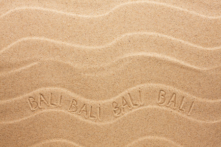 Bali inscription on the wavy sand, as backgroundの写真素材