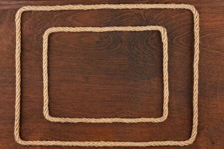 Frame of rope, lies on a background of a wooden surface, with place for your textの写真素材