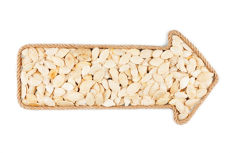 Arrow made of rope with  pumpkin seeds, on a white background