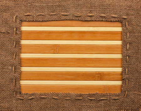 Frame of burlap, lies on a bamboo mat, with place for your textの写真素材