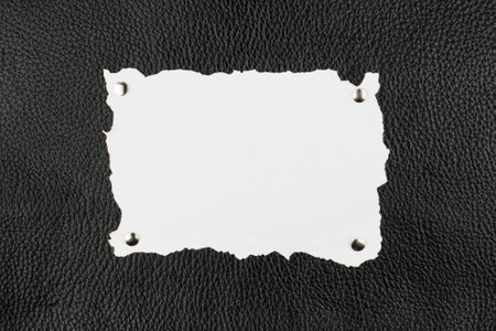 Old burnt paper pinned  buttons to black leather,as backgroundの写真素材