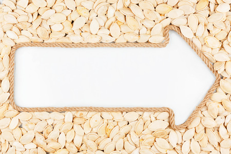 Arrow made of rope with pumpkin seeds  with a white background,with place for your textの写真素材