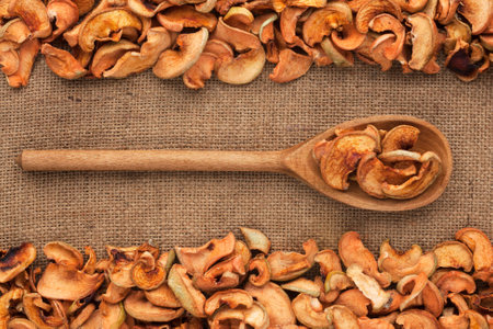 Wooden spoon with dried apple lies on  sackcloth,as backgroundの写真素材