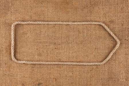 Arrow made of rope lying on burlap, as background, textureの写真素材
