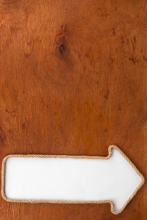 Pointer made of rope with a white background on the wood, with place for your textの写真素材