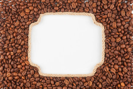 Figured frame  made of rope with  coffee beans  lying on a white background, with place for your text, graphicsの写真素材