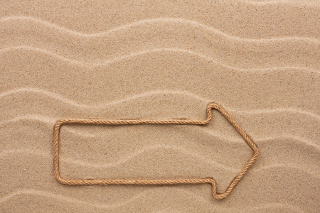 Pointer made of rope on the sandの写真素材