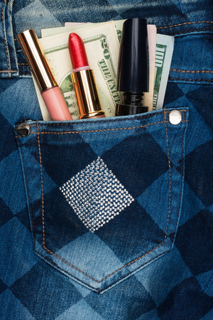 Cosmetics and money sticks out of the pocket of his jeans with rhinestones, as backgroundの写真素材