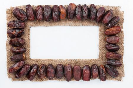 Frame made of burlap with dried date, on a white backgroundの写真素材