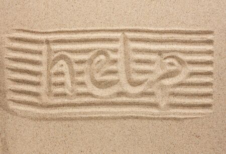 Word help written in the sand, as a backgroundの写真素材