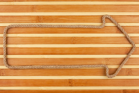 Arrow made of rope  lies on a bamboo mat, can be used as background, textureの写真素材