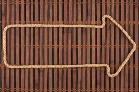 Arrow made of rope  lies on a bamboo mat, can be used as background, textureの写真素材