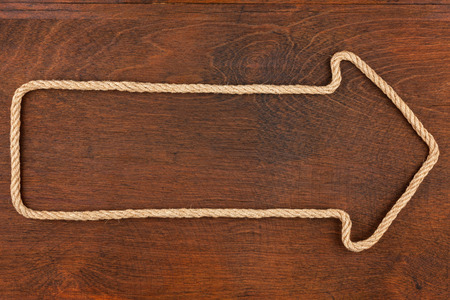Pointer made of rope with a white background on the wood, with place for your textの写真素材