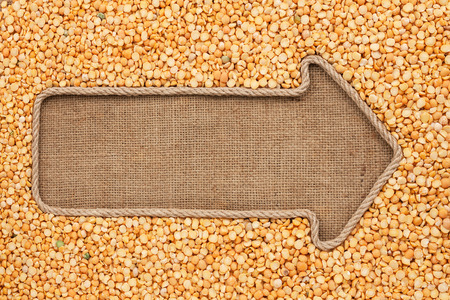 Pointer made from rope with grain peas  lying on sackcloth, with space for your textの写真素材