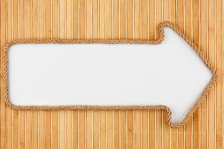 Pointer made of rope with a white background on the bamboo mat, with place for your textの写真素材