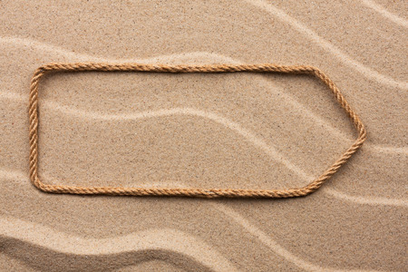 Pointer made of rope on the sand, with place for your textの写真素材