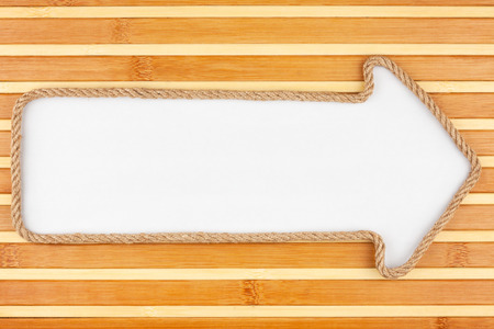 Pointer made of rope with a white background on the bamboo mat, with place for your textの写真素材