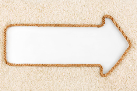 Arrow made of rope  and rice  with a white background, with place for your textの写真素材