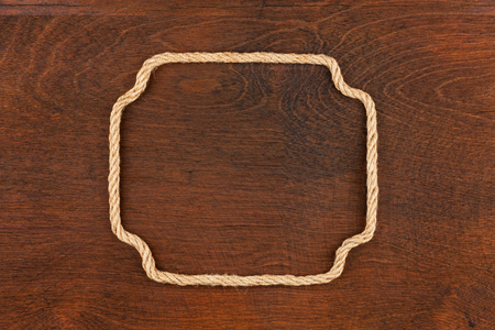 Frame of rope, lies on a background of a wooden surface, with place for your textの写真素材