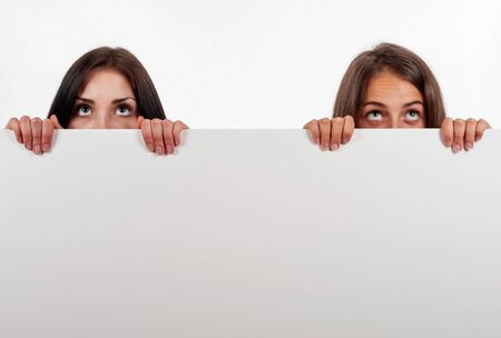 Beautiful brunette and blonde looking up, on white backgroundの写真素材