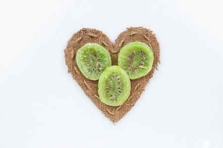 Kiwi  lies at the heart made of burlap on a white backgroundの写真素材