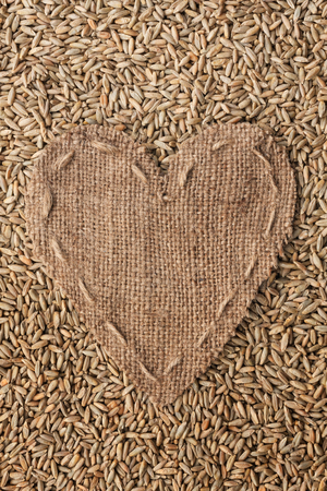 Frame in the shape of heart made of burlap with rye, with space for your textの写真素材