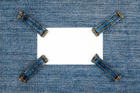 Business card with four straps jeans, lies on the light denim, with space for your textの写真素材