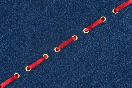 Fashionable background red satin ribbon inserted in denim, with space for your creativity