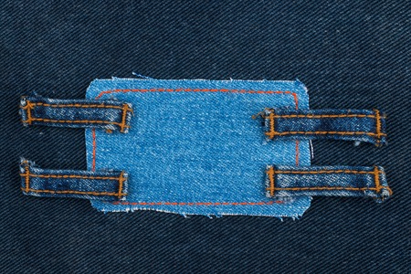 Frame made of denim with four straps of jeans, lies on the dark denim,