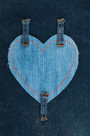 Heart made of denim fabric and attached three straps on dark denim, with space for your text