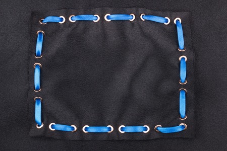 Blue ribbon is inserted in a frame made of black satin. With a place for your text