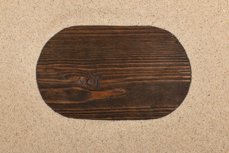 Empty frame of dark wood lying in sand. Copy space. Top viewの写真素材