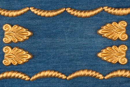 Luxury frame made of gold stucco plaster lying on denim. With space for your textの写真素材